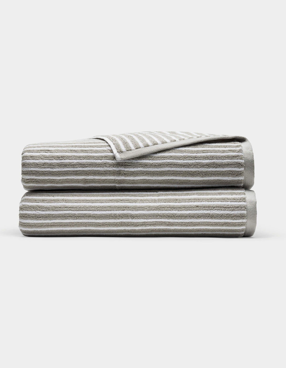 Two Cozy Earth Ribbed Terry Bath Sheets in gray and white stripes are folded and stacked on each other against a plain white background.|Color:Dew Stripe