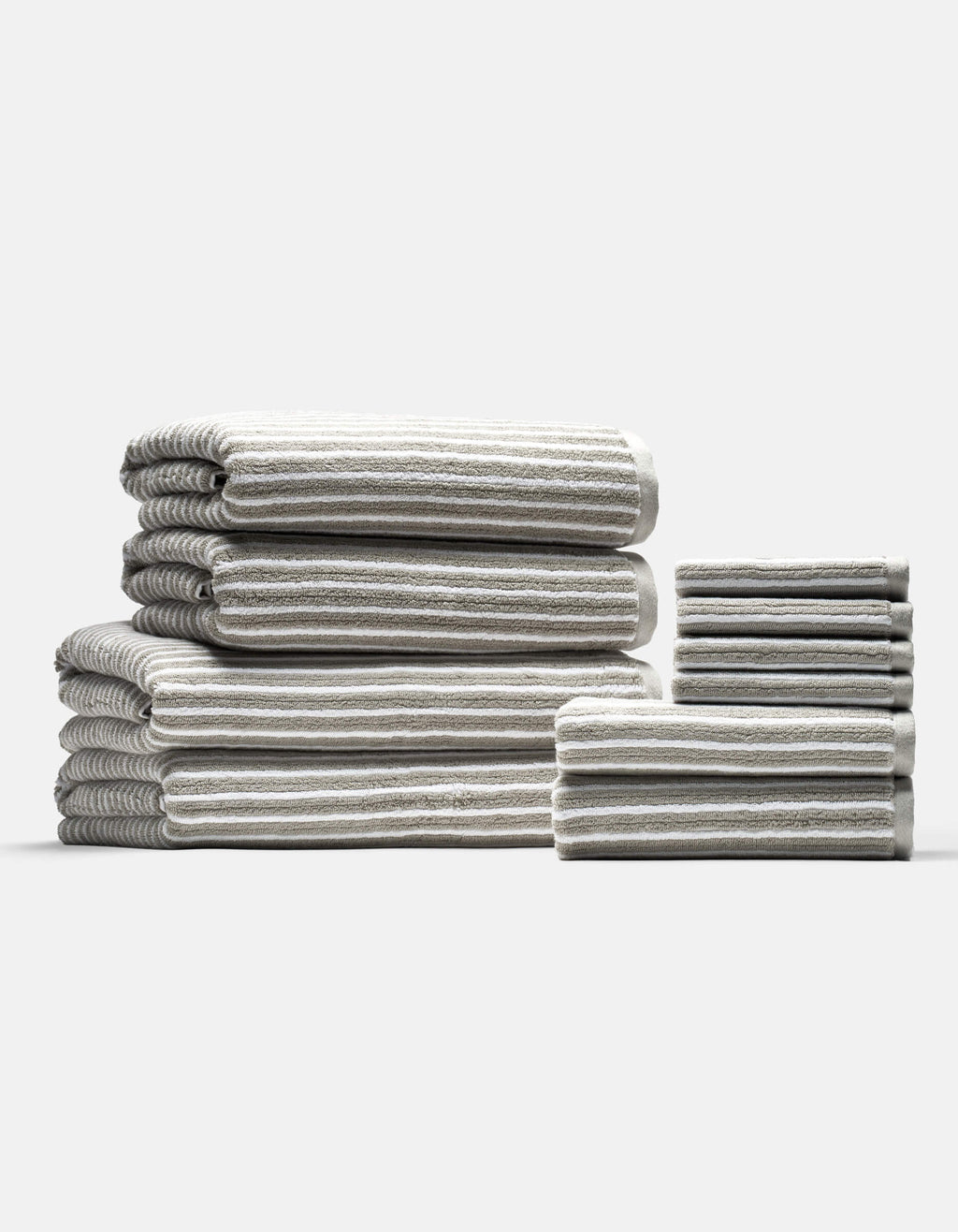 The Cozy Earth Complete Ribbed Terry Bath Bundle features gray and white striped towels in various sizes, neatly folded and arranged into two stacks on a plain light background.|Color:Dew Stripe