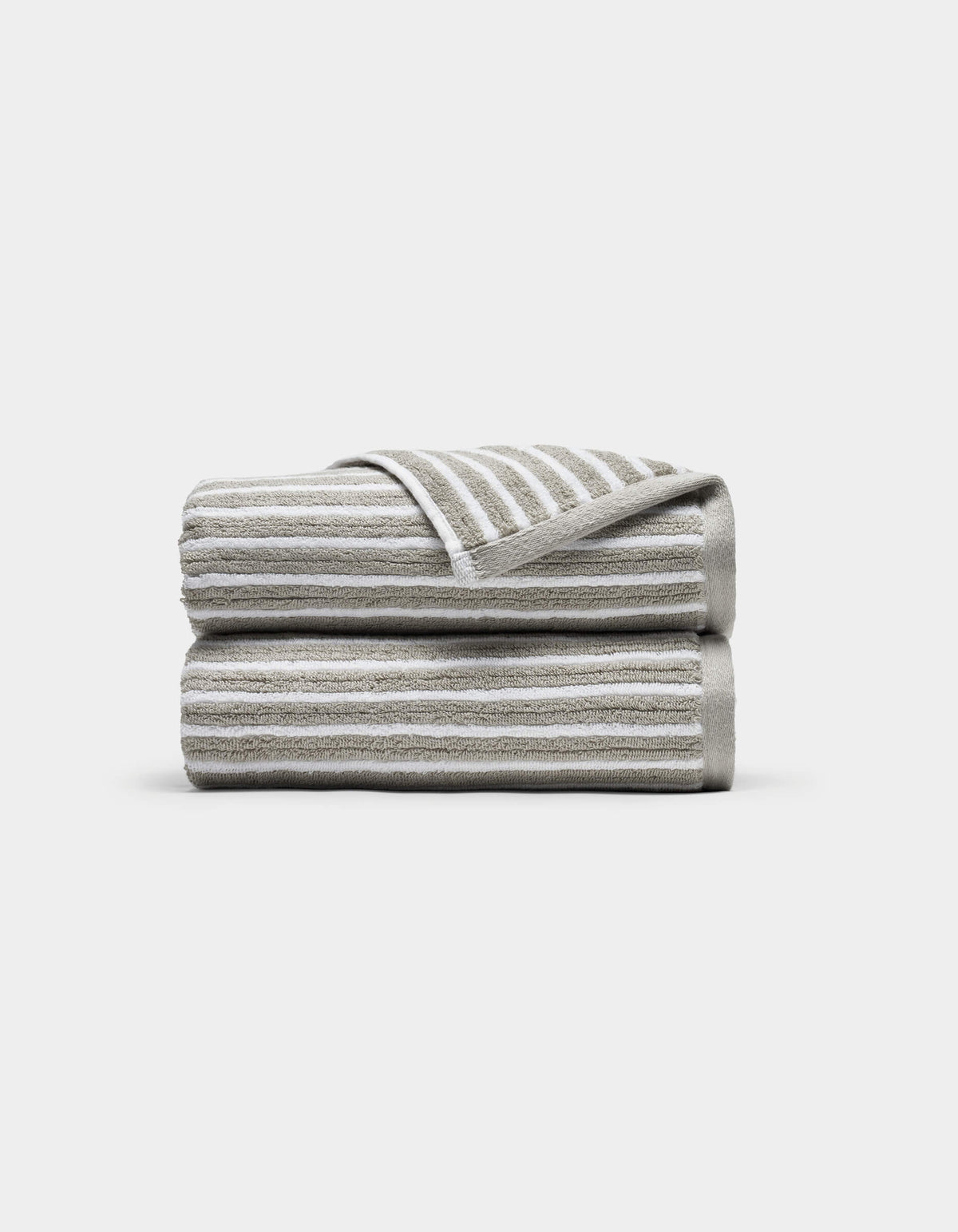 Two Ribbed Terry Hand Towels by Cozy Earth, in beige and white stripes, stacked neatly with one corner of the top towel flipped to show the stripe pattern, set against a plain white background.|Color:Dew Stripe