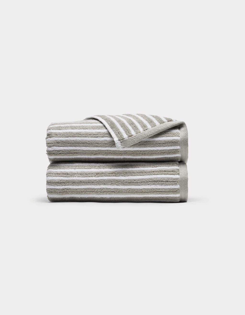 Two Ribbed Terry Hand Towels by Cozy Earth, in beige and white stripes, stacked neatly with one corner of the top towel flipped to show the stripe pattern, set against a plain white background.|Color:Dew Stripe