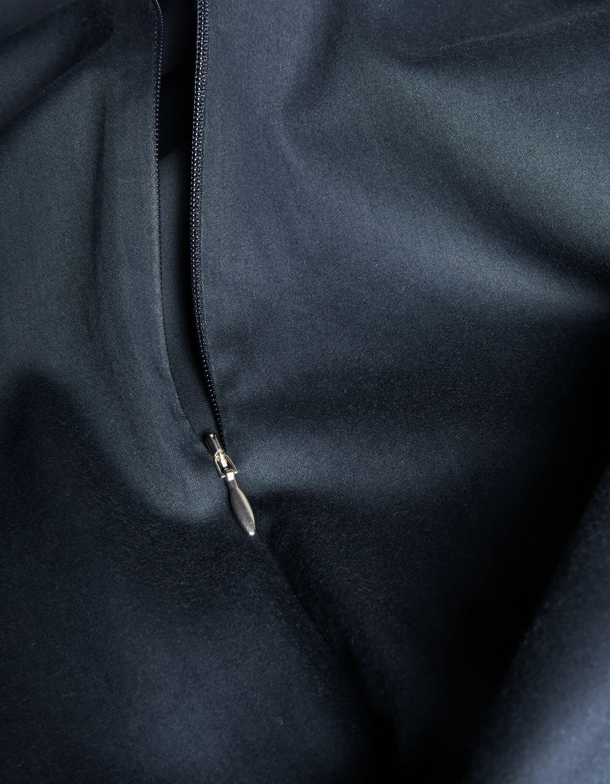 Close-up of Cozy Earth's Soft-Wash Cotton Duvet Cover featuring a partially opened zipper, highlighting the smooth texture and subtle sheen of the premium dark cotton fabric.|Color:Eclipse
