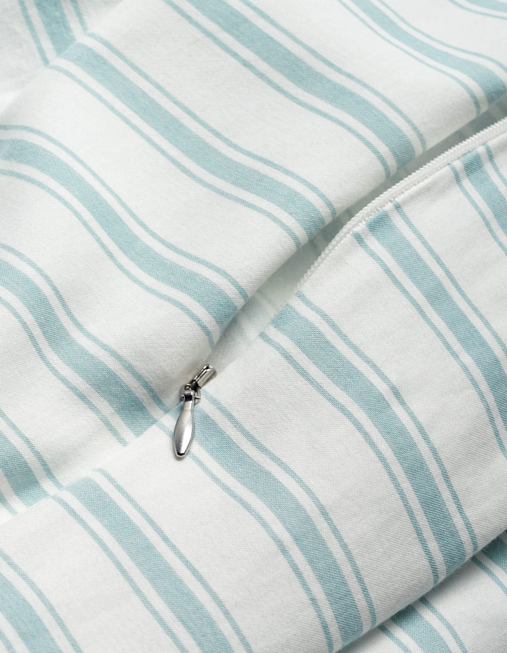 Close-up of the Cozy Earth Soft-Wash Cotton Duvet Cover in white with light blue stripes, highlighting a partially unzipped silver zipper.|Color:River and Sea Salt Stripe