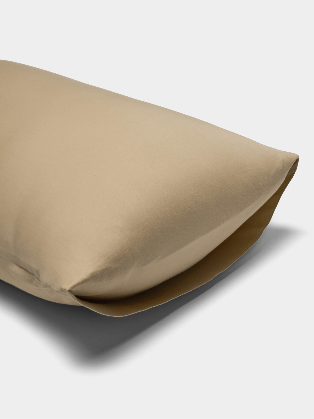 A Cozy Earth Soft-Wash Cotton Pillowcase in beige is displayed on a white background, shown slightly open at one end to reveal the pillow inside.|Color:Sandalwood