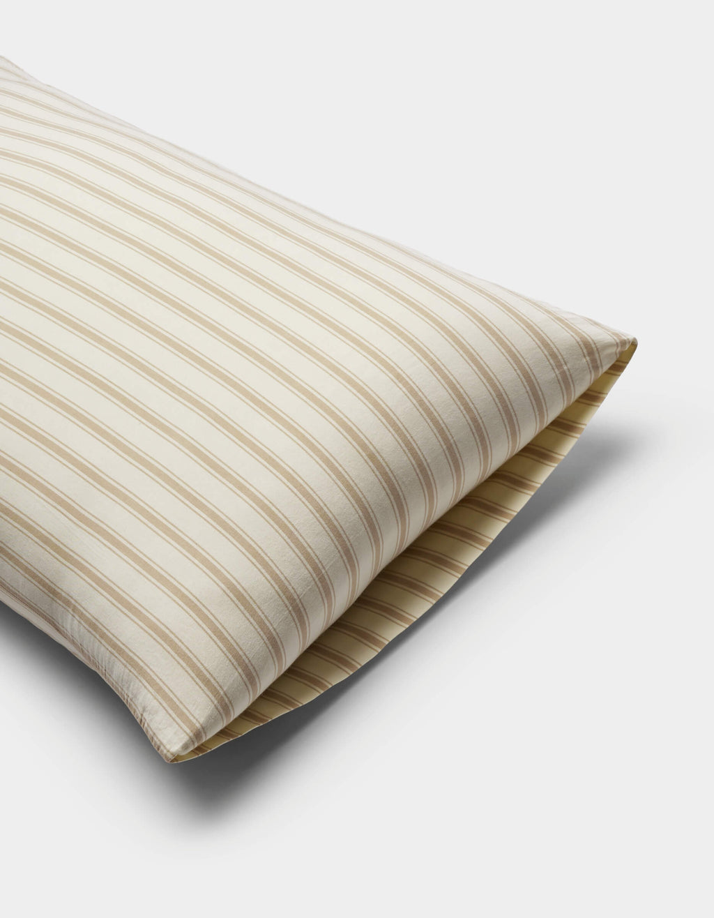 The Cozy Earth Soft-Wash Cotton Pillowcases in beige and white stripes are displayed on a plain white background, partially angled to highlight their soft texture and classic design.|Color:Coconut and Sandalwood Stripe