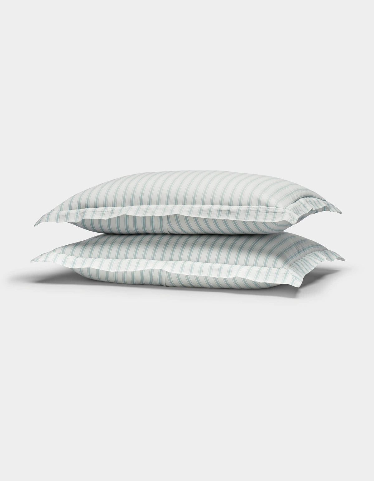 Two Cozy Earth Soft-Wash Cotton Quilted Shams in white with light blue and gray stripes are stacked together against a plain white background.|Color:River and Sea Salt Stripe