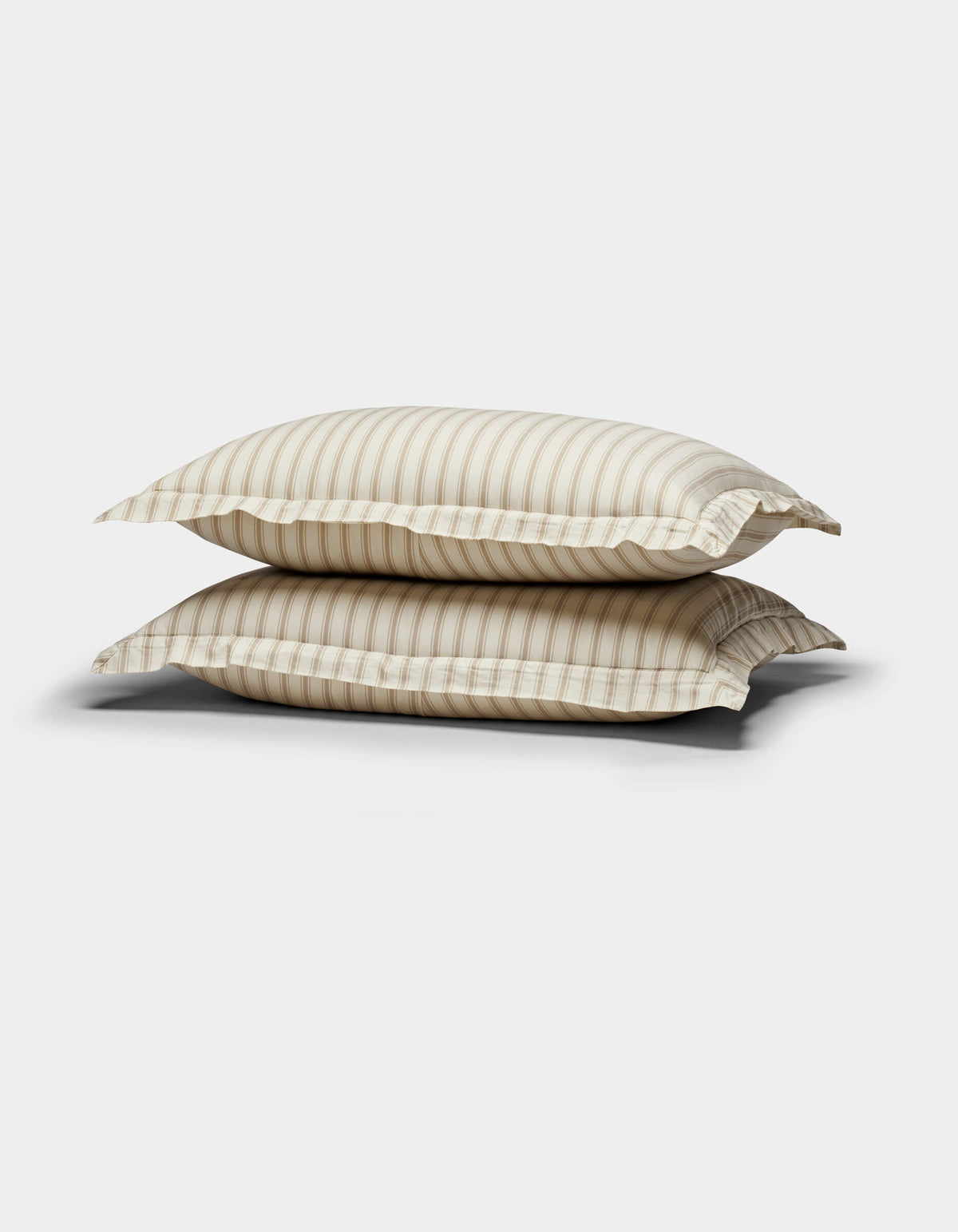 The Soft-Wash Cotton Duvet Set by Cozy Earth is showcased, neatly stacked with its subtle beige tones and gentle horizontal stripes against a plain white background.|Color:Coconut and Sandalwood Stripe