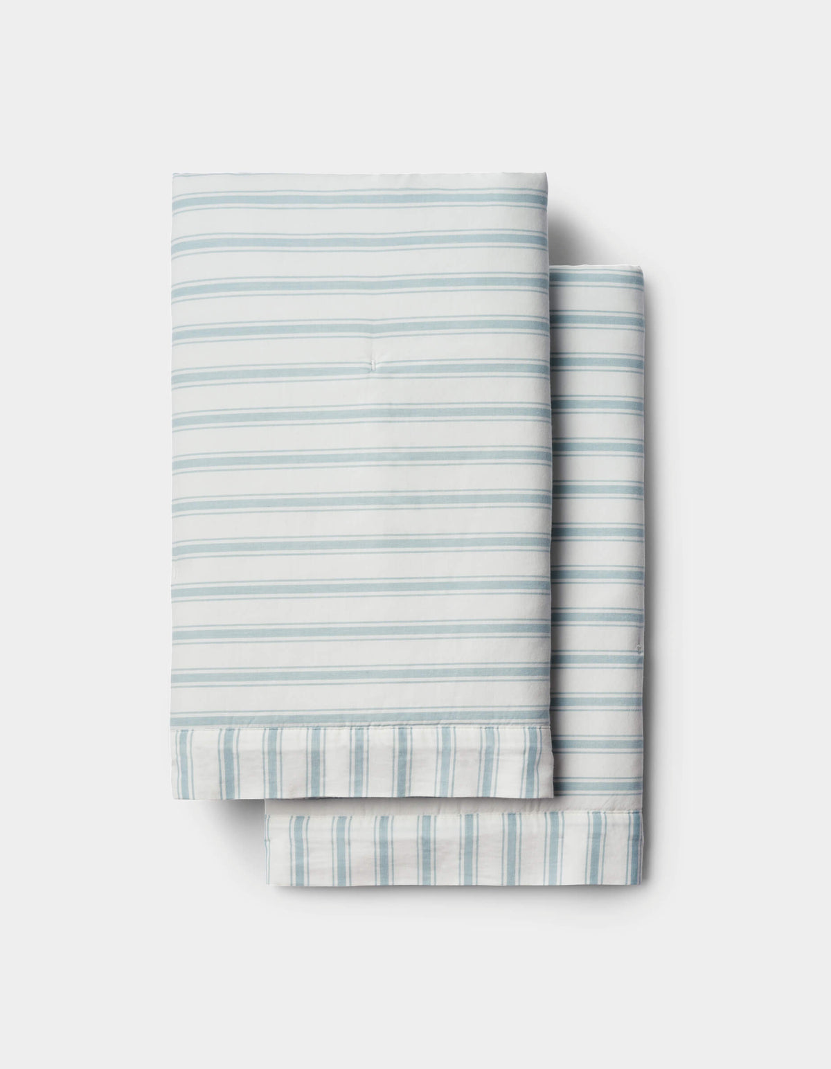 Soft-Wash Cotton Quilted Shams by Cozy Earth in light blue and white stripes are neatly folded and stacked on a white background.|Color:River and Sea Salt Stripe