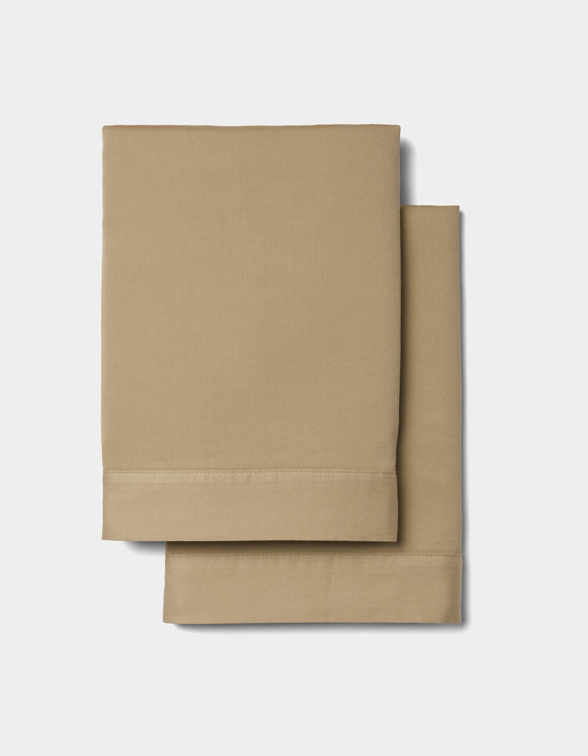 Two neatly folded Cozy Earth Soft-Wash Cotton Duvet Sets, in beige, are stacked on a plain white background. The sets feature a smooth texture and seam detailing along the edges.|Color:Sandalwood