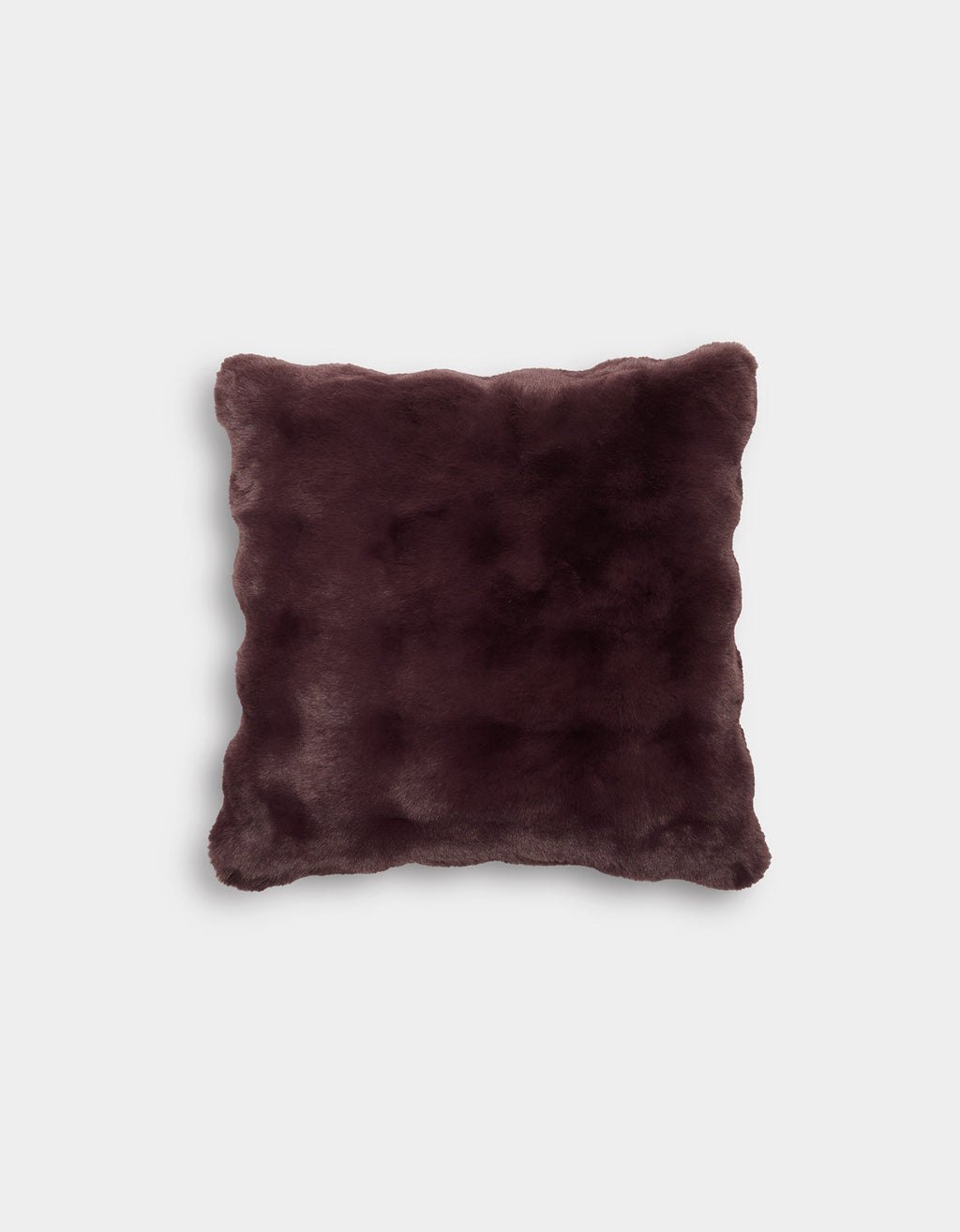 The Bubble Cuddle Pillow by Cozy Earth is displayed against a plain light gray background. This square pillow features a dark brown, faux fur cover with a soft, plush texture and gently rounded corners.|Color:Raisin |Size:20" x 20"