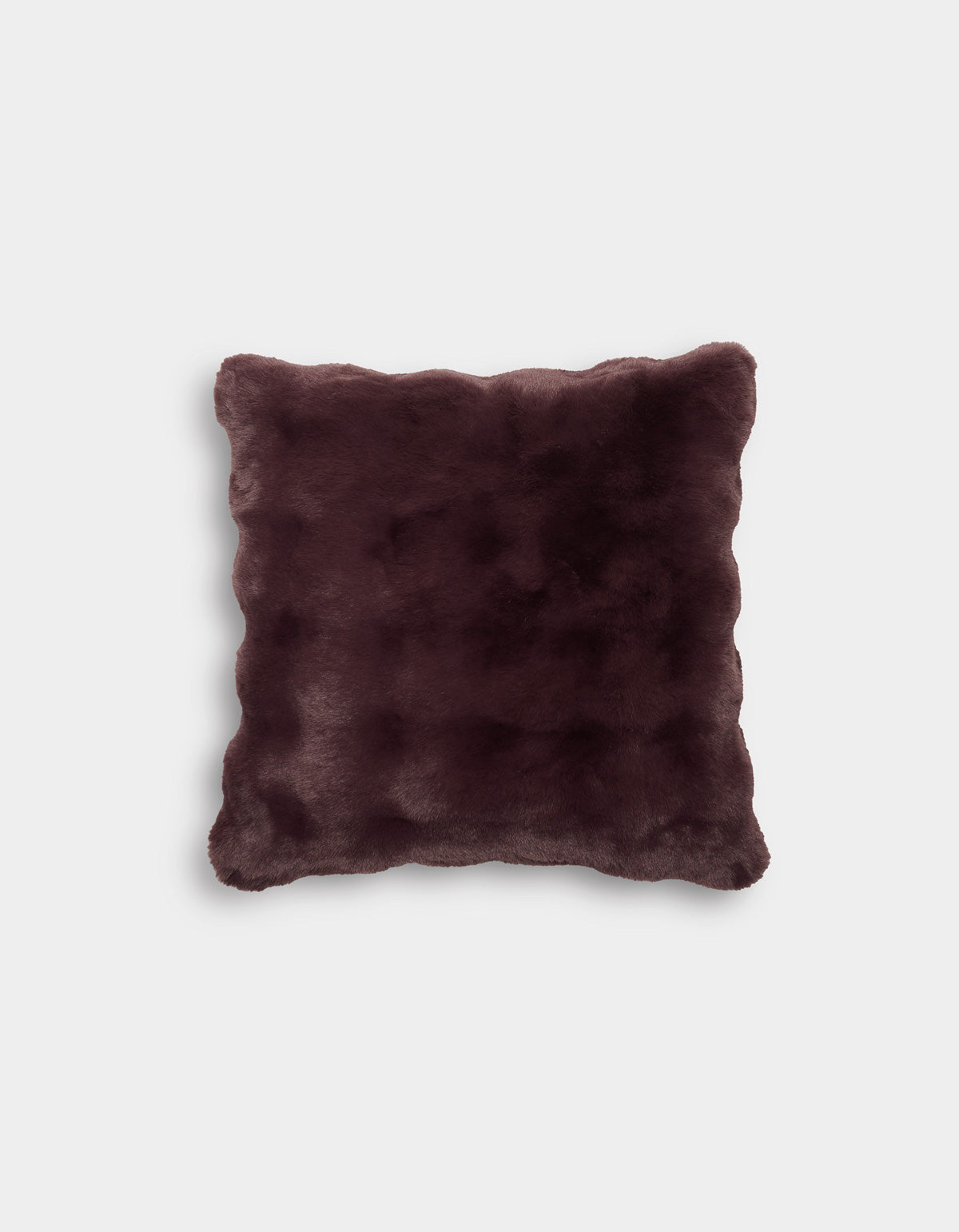 The Bubble Cuddle Pillow by Cozy Earth is displayed against a plain light gray background. This square pillow features a dark brown, faux fur cover with a soft, plush texture and gently rounded corners.|Color:Raisin |Size:20" x 20"