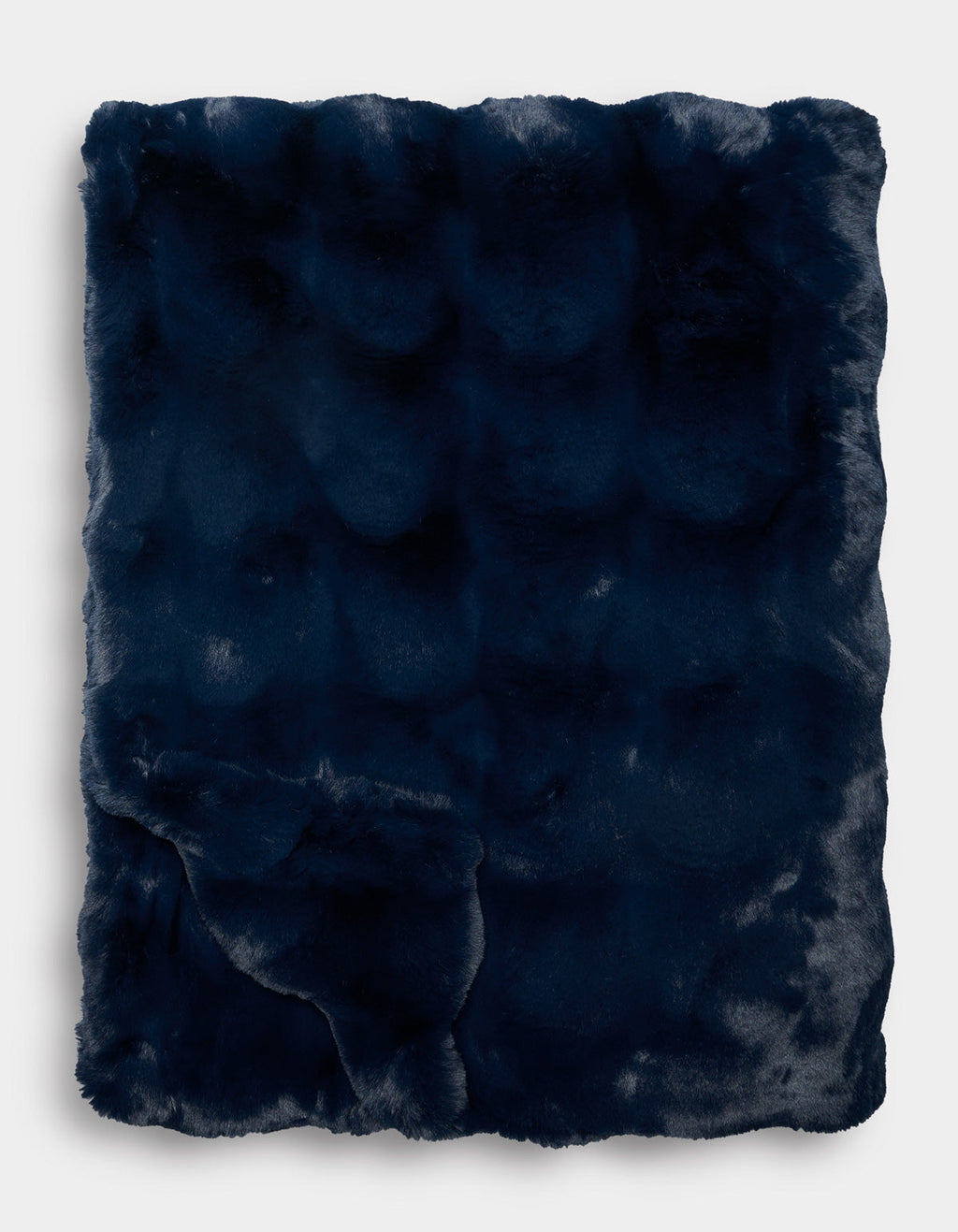 The Double Bubble Cuddle Blanket by Cozy Earth, in dark navy blue faux fur, is folded neatly to display its plush, soft texture and subtle sheen against a plain white background.|Color:Eclipse
