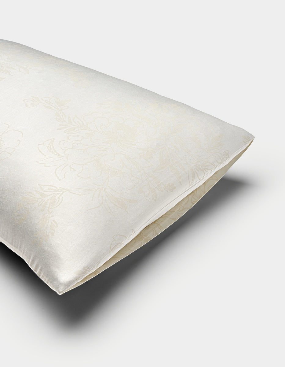 A close-up of a Cozy Earth Bamboo Pillowcase in cream, showing its envelope closure and subtle floral pattern on the satin-like fabric.|Color:Sonoma Floral in Vintage White