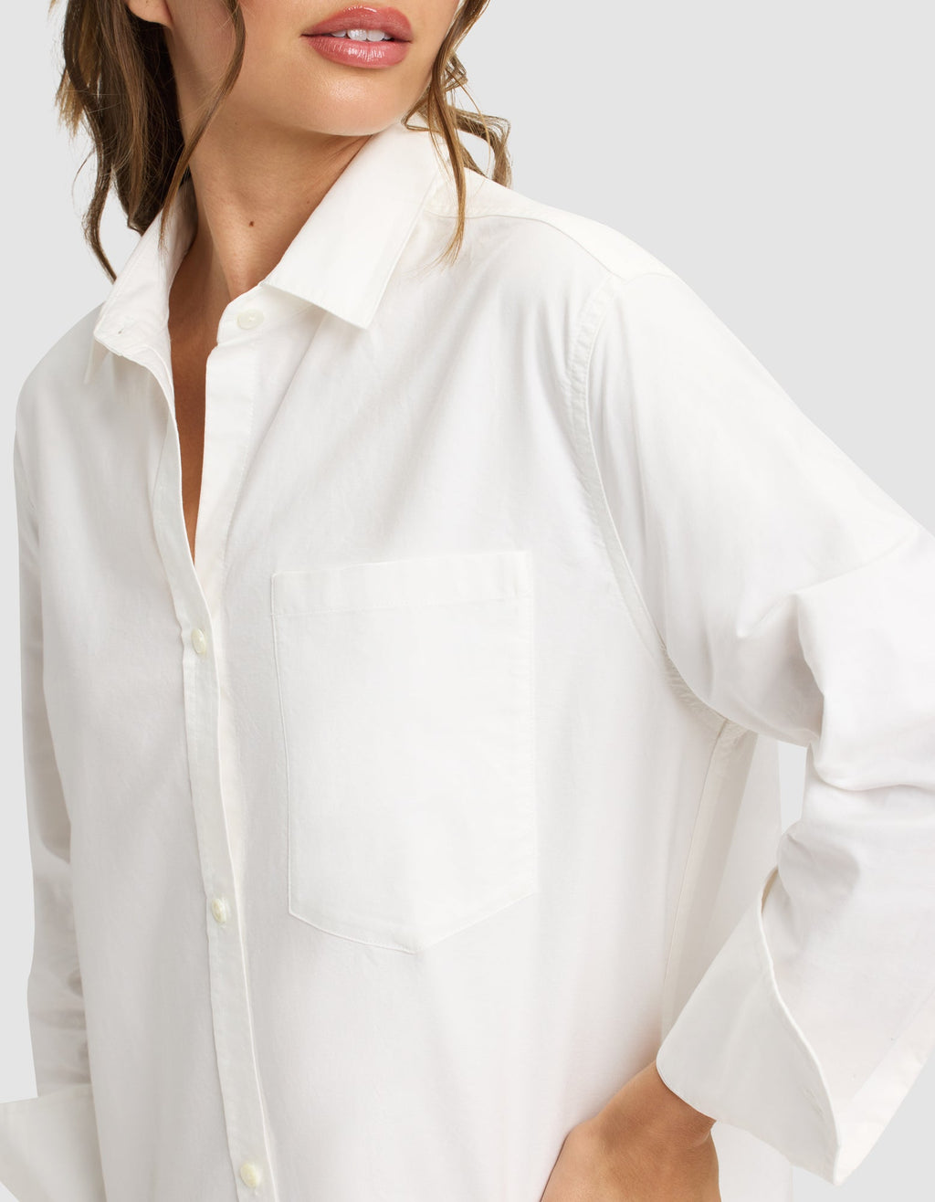 A woman models the Cozy Earth Women's Camden Midi Dress, standing with one hand on her hip against a light gray background. Her face is partially visible, showing only her lips and chin. |Color:White