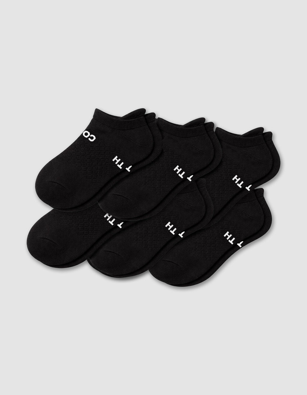 Six pairs of Cozy Earth Men's Essential Ankle Socks in black are neatly arranged on a light gray background, each featuring small white text near the toe.|Color:Black