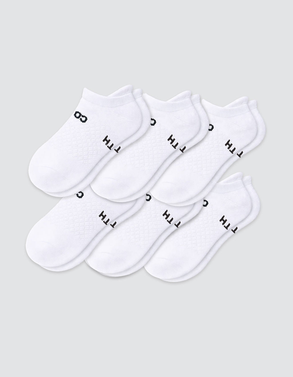 Six pairs of Cozy Earth Women's Essential Ankle Socks in white, featuring black text near the elastic opening, are arranged in two overlapping rows on a light gray background.|Color:White