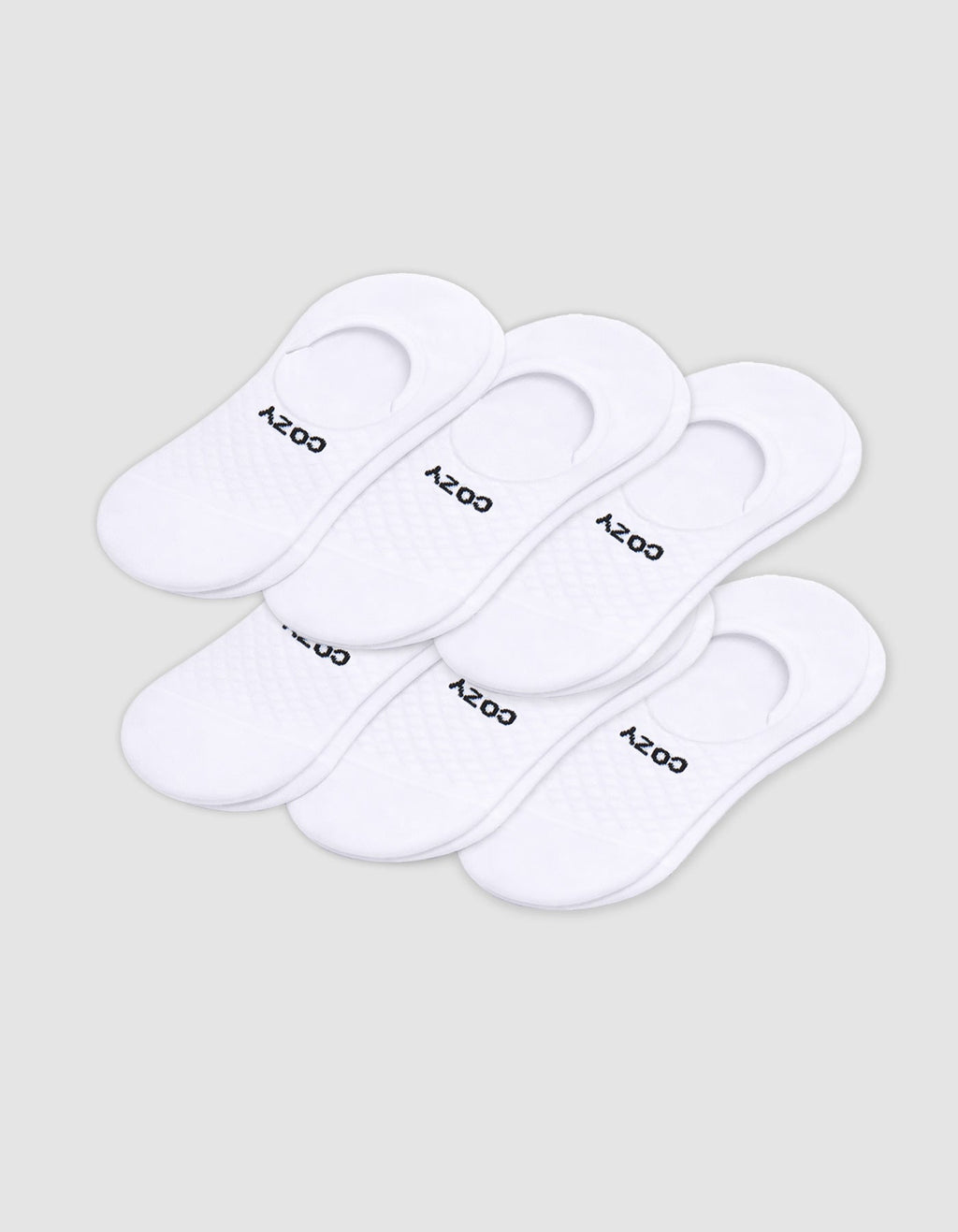 Six pairs of Cozy Earth Men's Essential No-Show Socks are stacked on a plain white background, each featuring "COZY" printed in black near the heel opening.|Color:White
