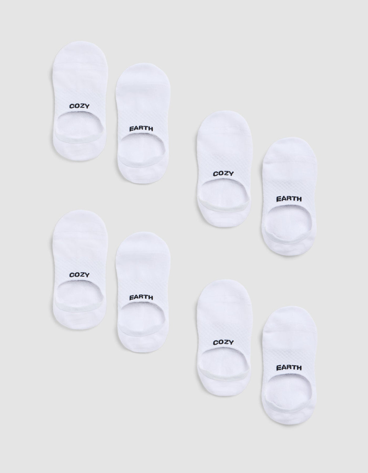 Eight pairs of white socks from the Cozy Earth Essential No-Show Sock 4-Pack are arranged on a light grey background, each sock featuring "COZY" or "EARTH" in black text at the toes.|Color:White