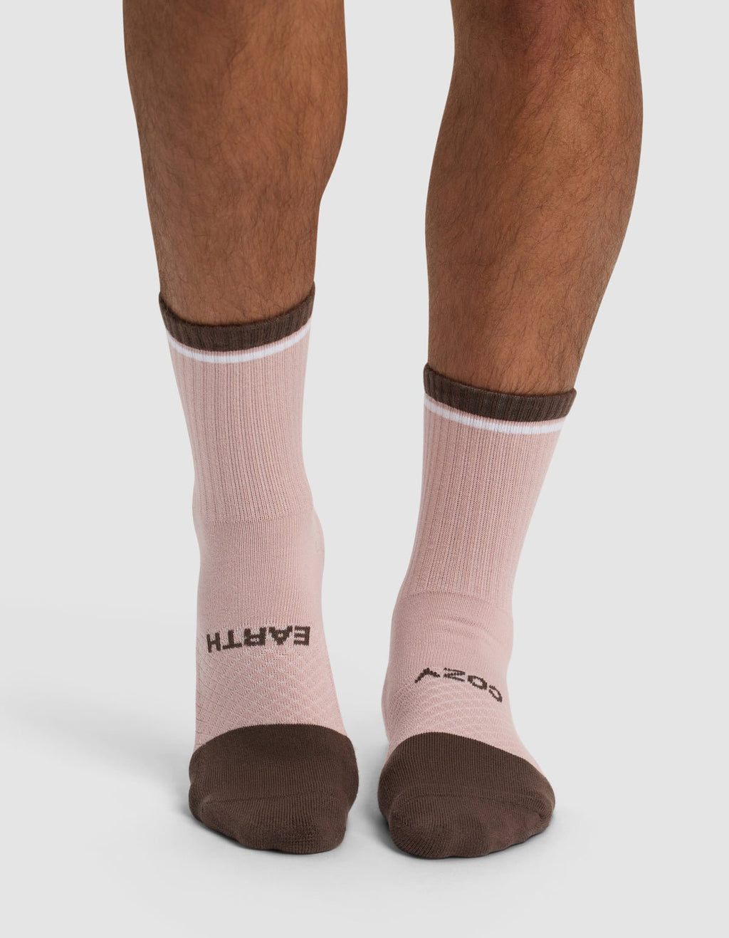 A person wears Cozy Earth's Essential Calf Socks in pink with brown toes and cuffs; "EARTH" is printed in black on the left sock and "COZY" on the right, both across the tops of the feet.|Color:Cedar