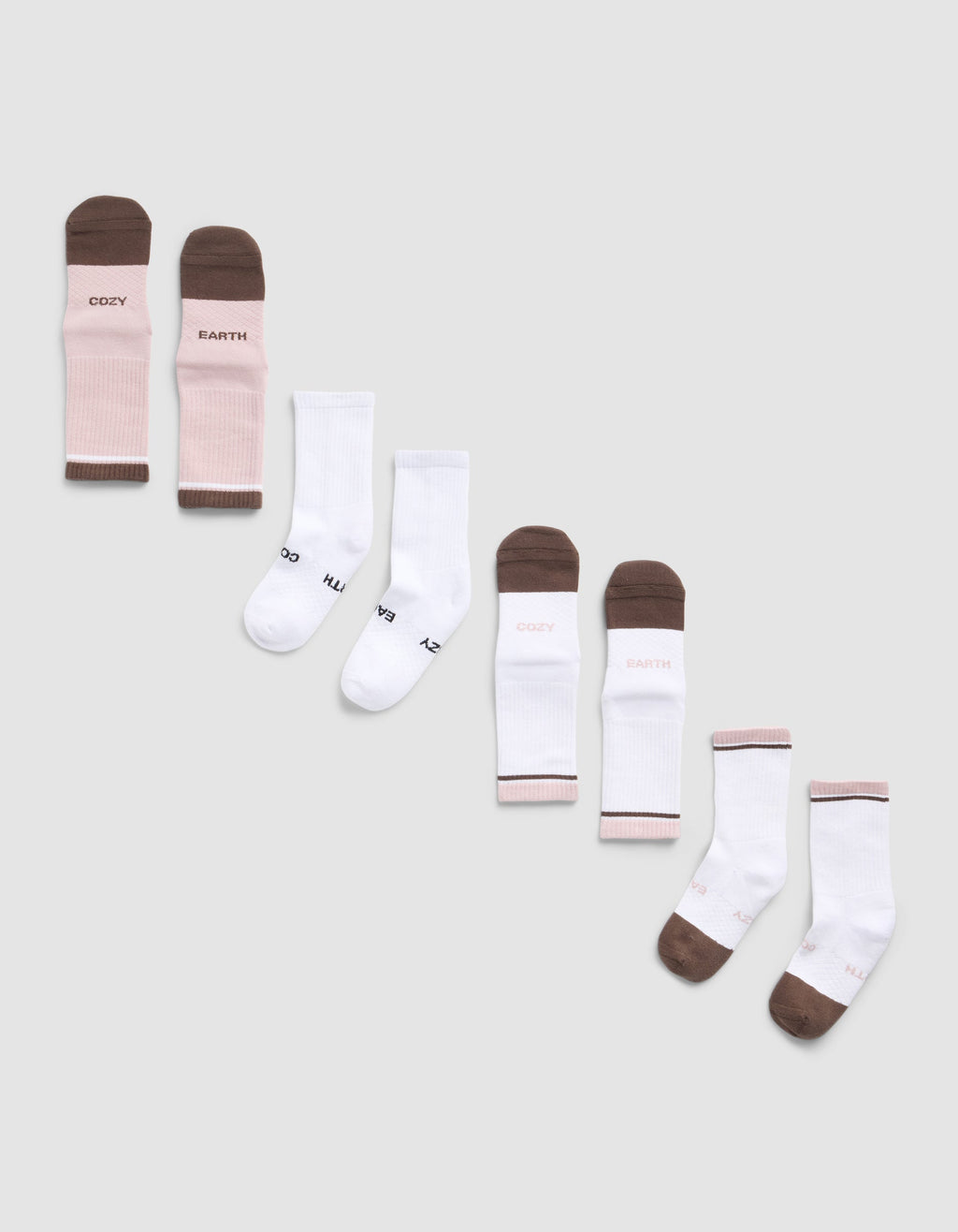 The Essential Calf Sock 4-Pack by Cozy Earth features four pairs of socks—two white, one pink and brown with "COZY EARTH" text, and one white with brown toes and heels also featuring the brand’s logo.|Color:Cedar