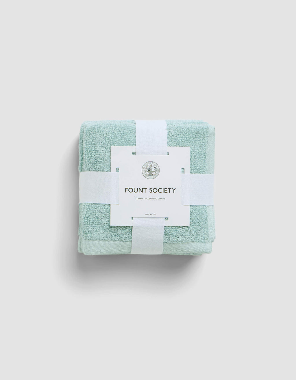 A neatly folded light green Complete Cleansing Cloth by Cozy Earth, secured with white bands and branded tag, rests against a light gray background.|Color:Tide