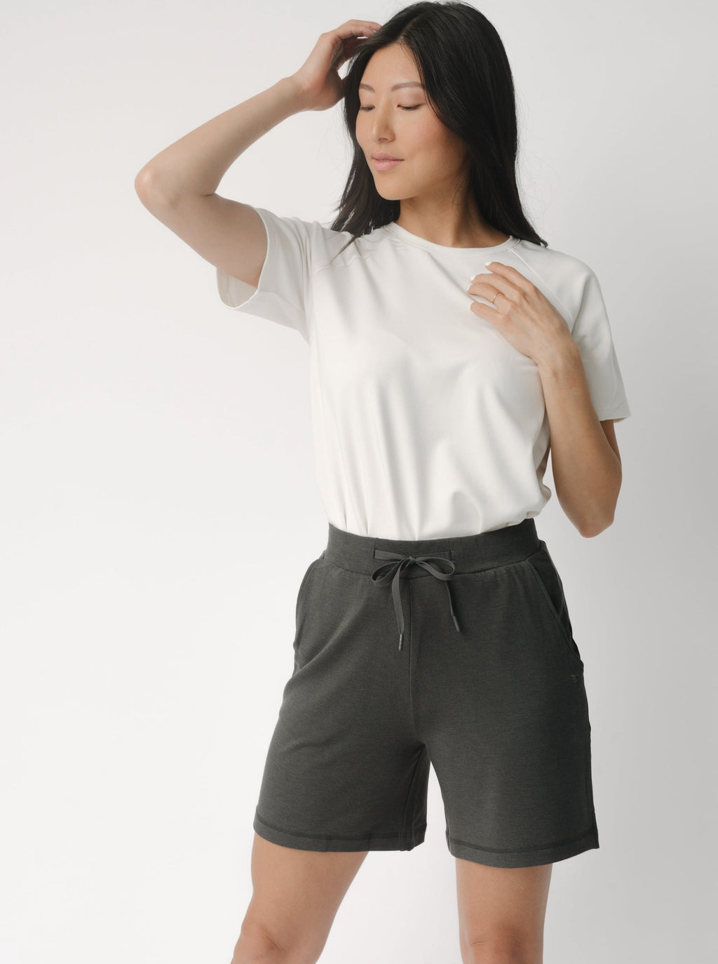 Woman wearing a white t-shirt and grey Cozy Earth Brushed Bamboo Mid-Length Shorts shorts on a plain background |Color:Charcoal