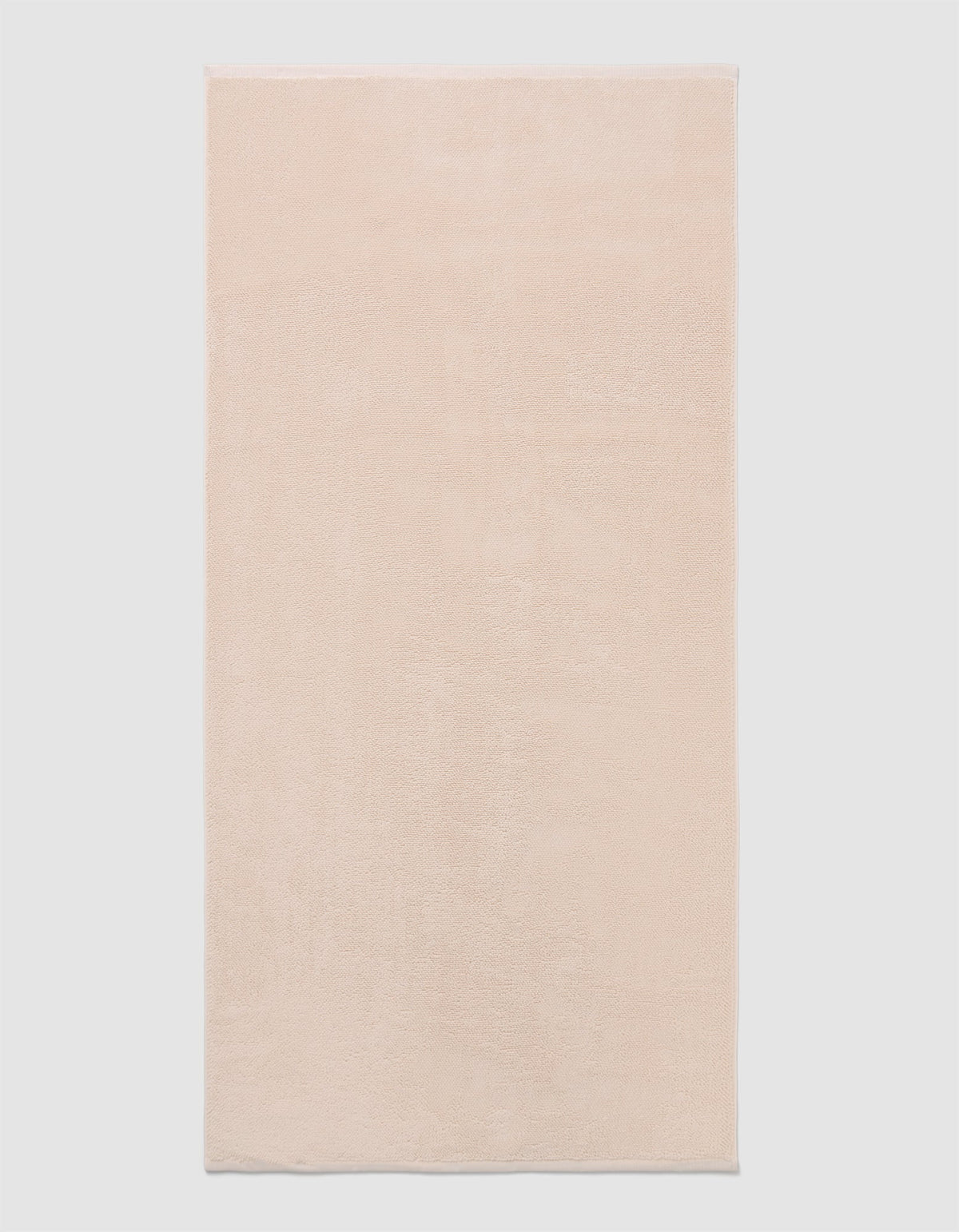 The Cozy Earth Loop Terry Bath Mat, a rectangular bath mat in light beige with a soft, plush texture, is displayed against a plain white background.|Color:Petal