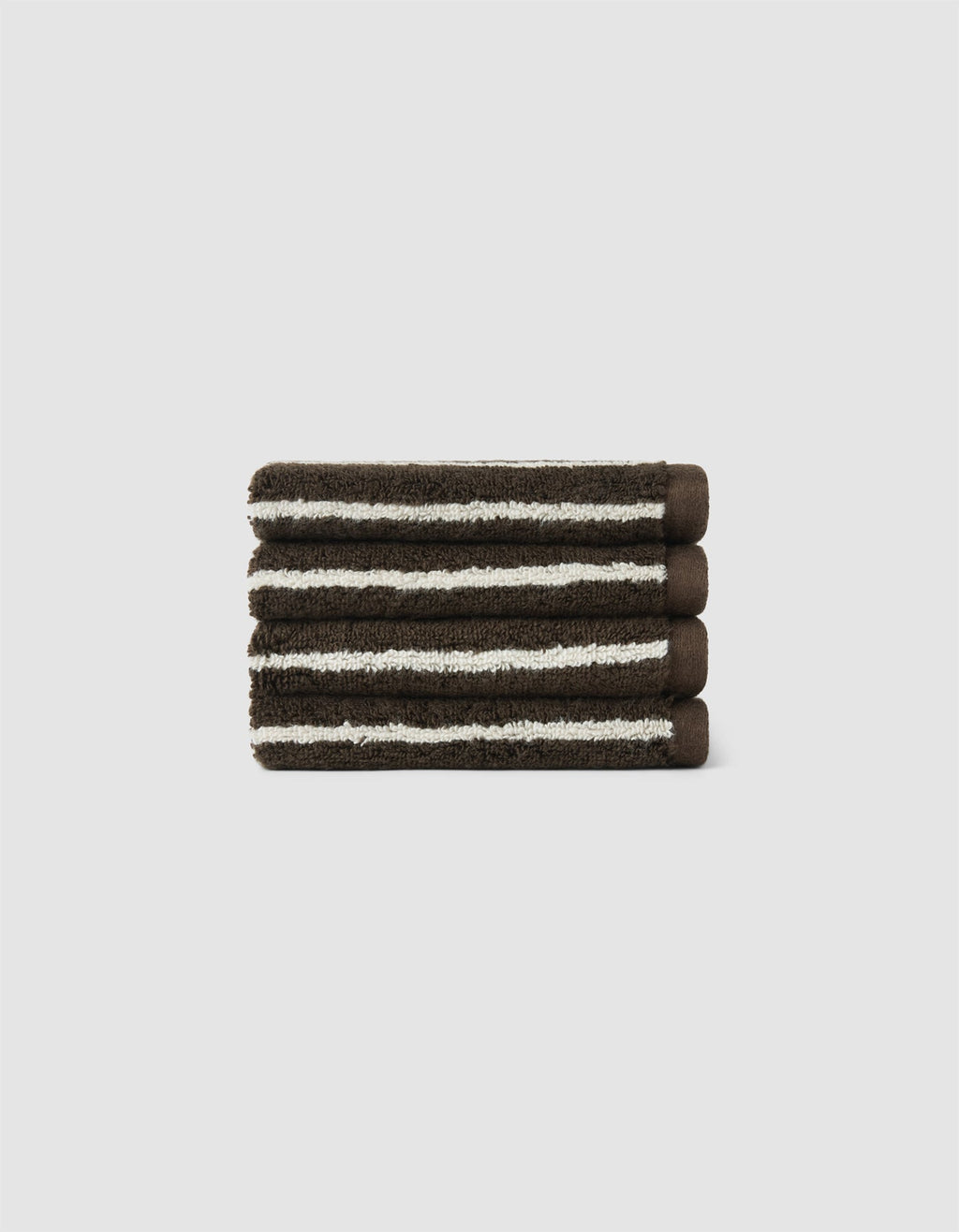 The Cozy Earth Striped Luxe Bath Towel Set features three neatly folded dark brown towels with white stripes, stacked on a light gray background.|Color:Espresso Coconut Stripe