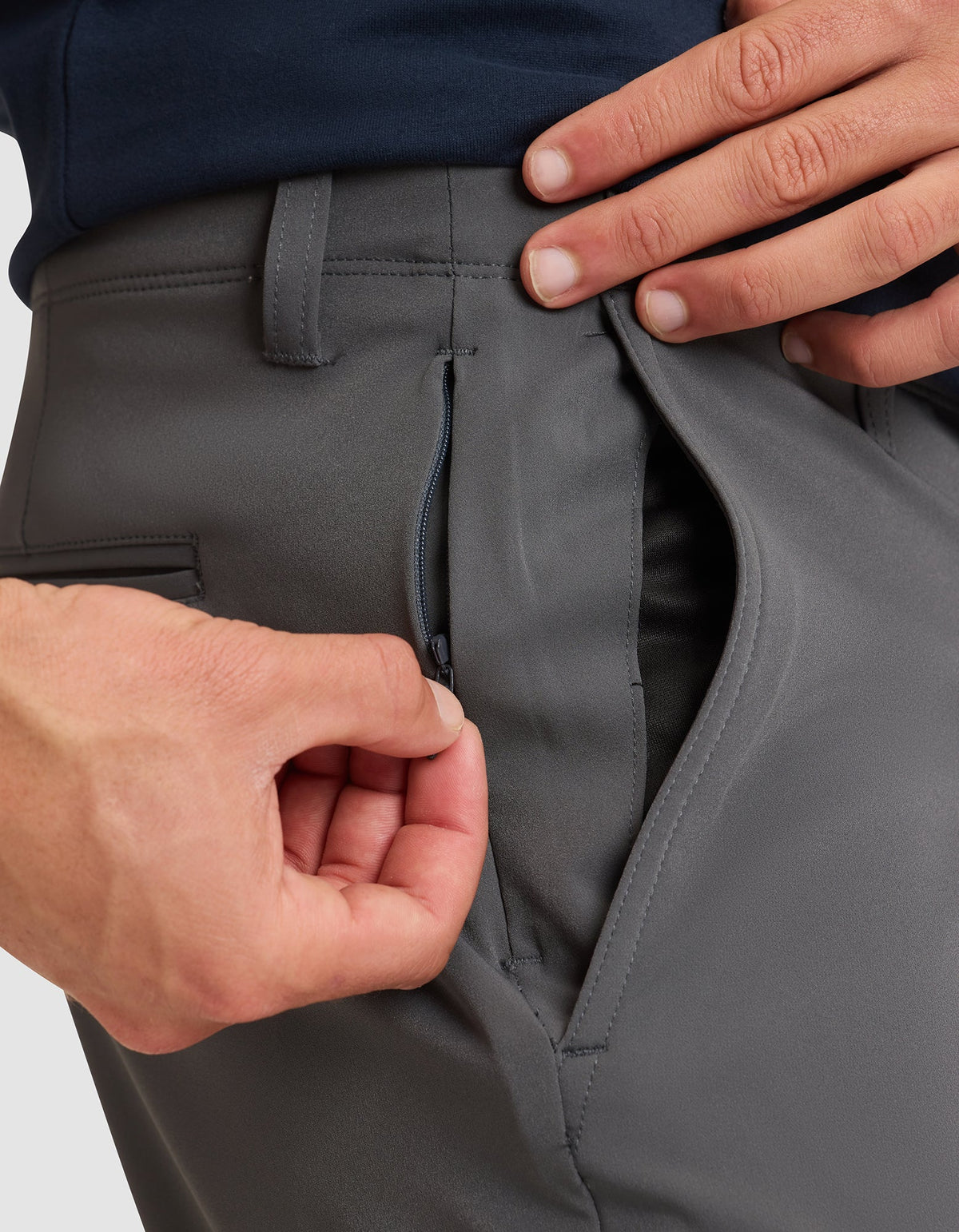A close-up shows a person using their left hand to unzip the hidden zipper pocket inside the right side pocket of Cozy Earth's Men's Everywhere Pant (gray).  |Color:Coal