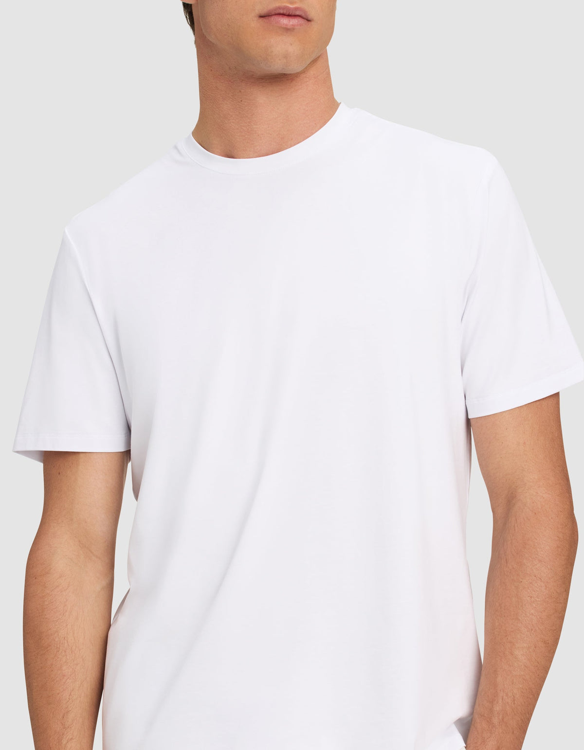 A man wears the Cozy Earth Men's First Layer Pajama Short Sleeve Tee, shown from shoulders to waist against a light gray background. His face is partially out of frame.|Color:White