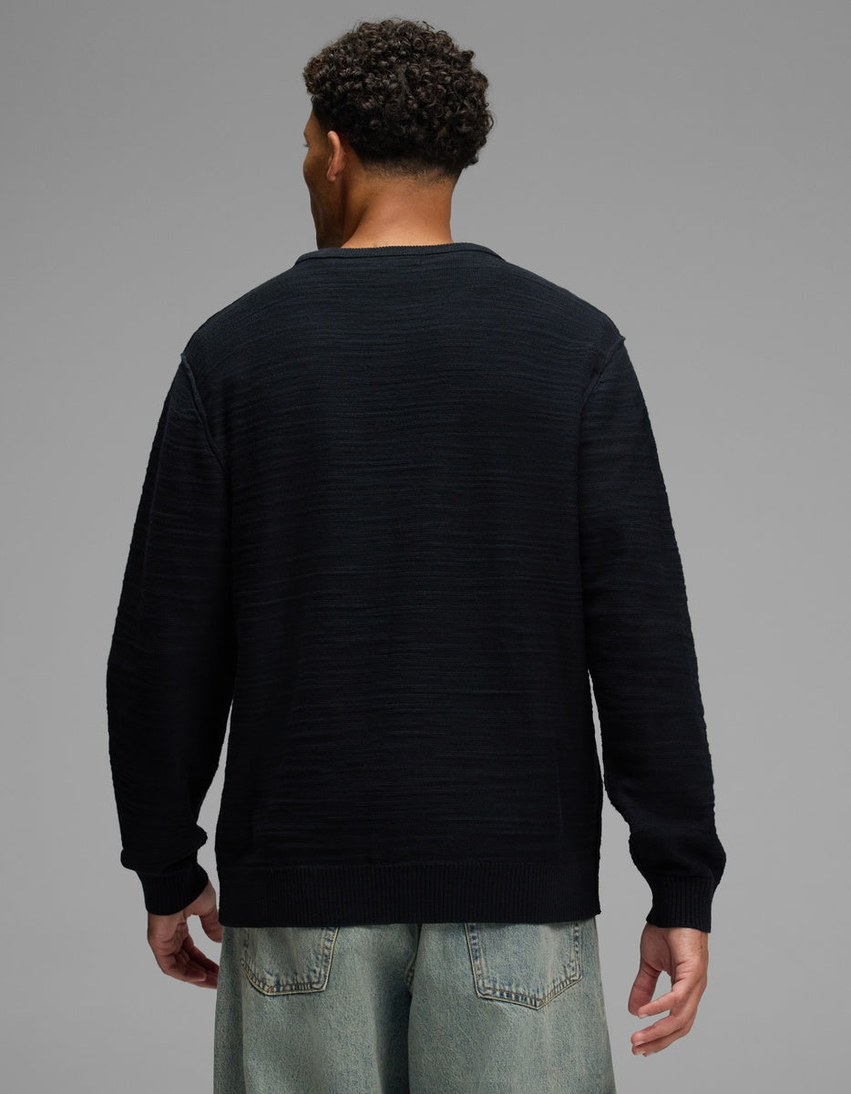 A man from behind wearing a black, ribbed-texture Men’s Tate Crewneck sweater.|Color:Jet Black