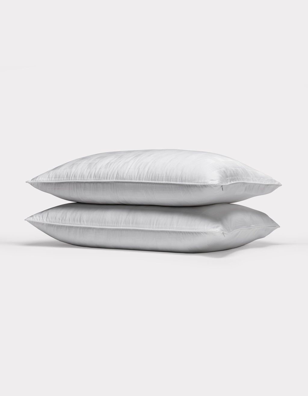 Two Cozy Earth Pillow Protectors are stacked together against a plain, light gray background.