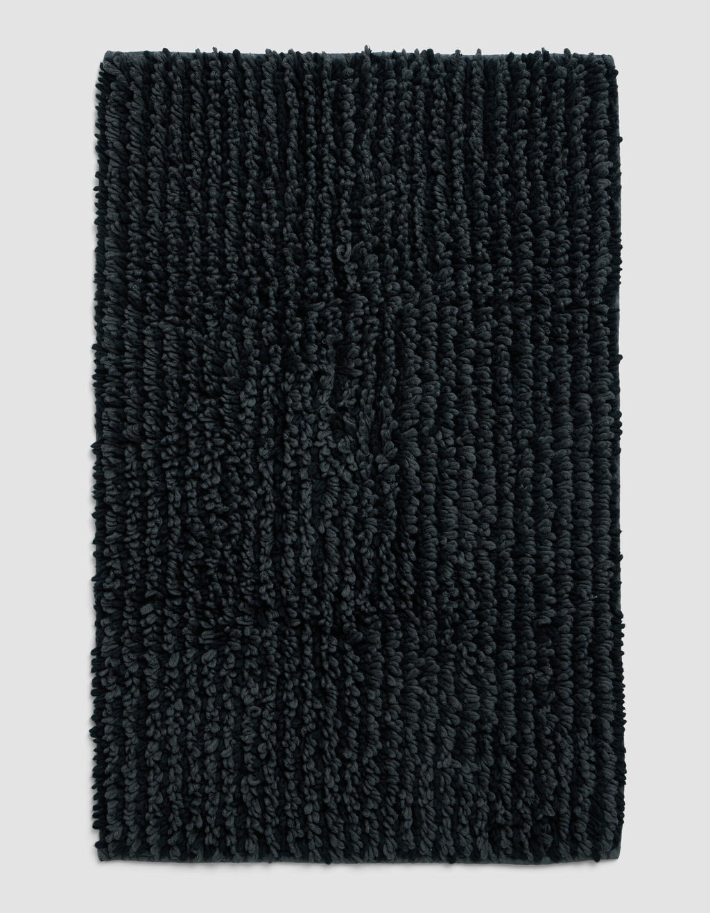 The Cozy Earth Plush Loop Bath Mat, rectangular and dark gray with thick textured fibers, is displayed on a plain light gray background.|Color:Graphite