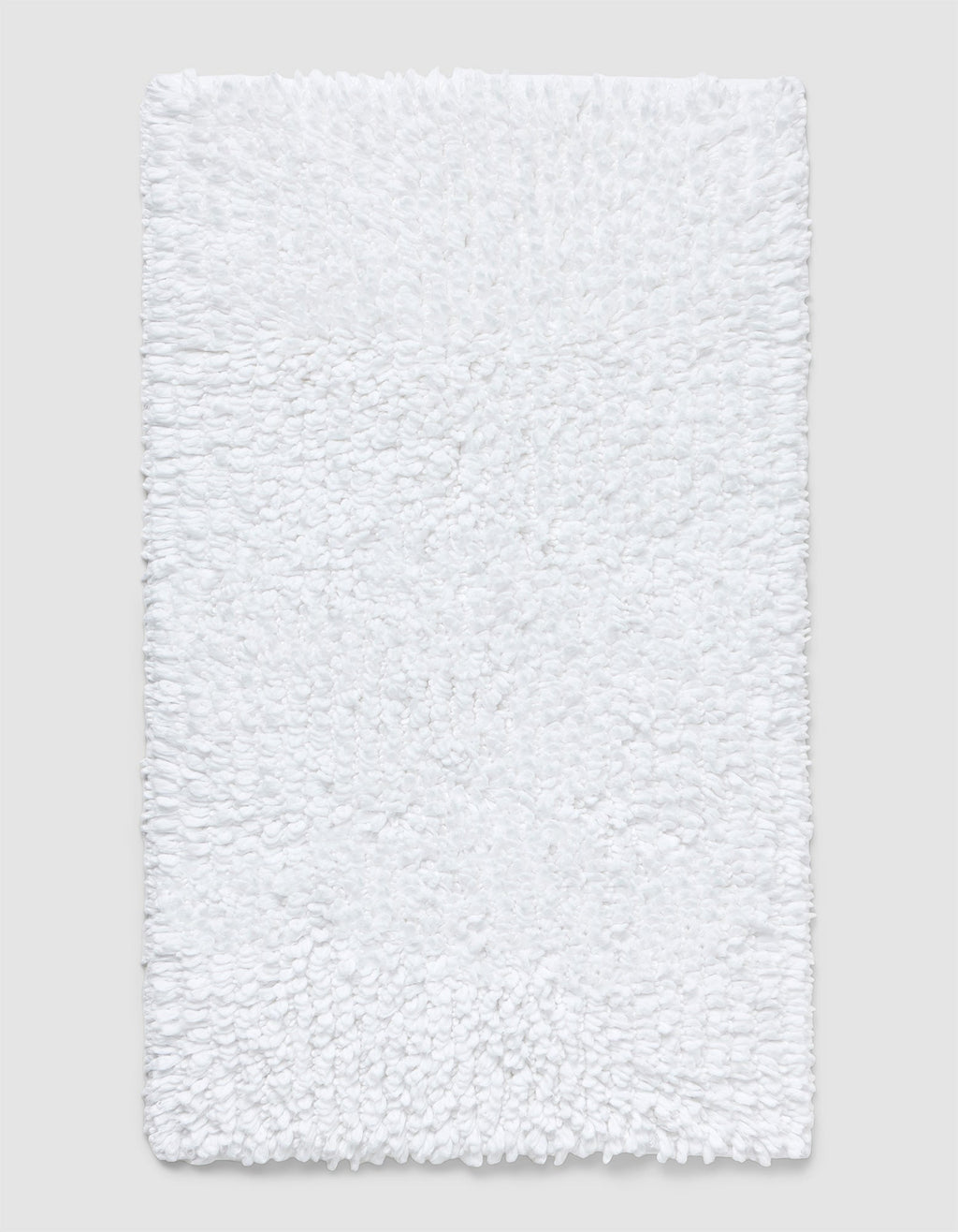 The Cozy Earth Plush Loop Bath Mat is rectangular, white, and features a soft, fluffy chenille shag texture. Shown on a plain light background, it offers plush comfort with its textured surface.|Color:White