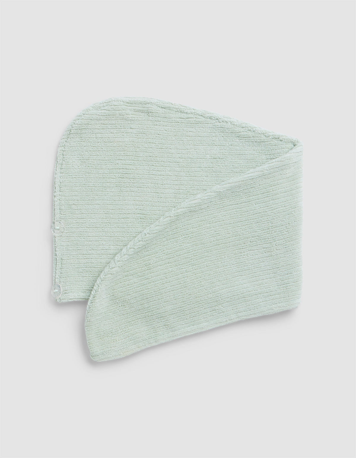 A Cozy Earth Ribbed Terry Hair Towel in light green is folded neatly against a plain white background.|Color:Laurel