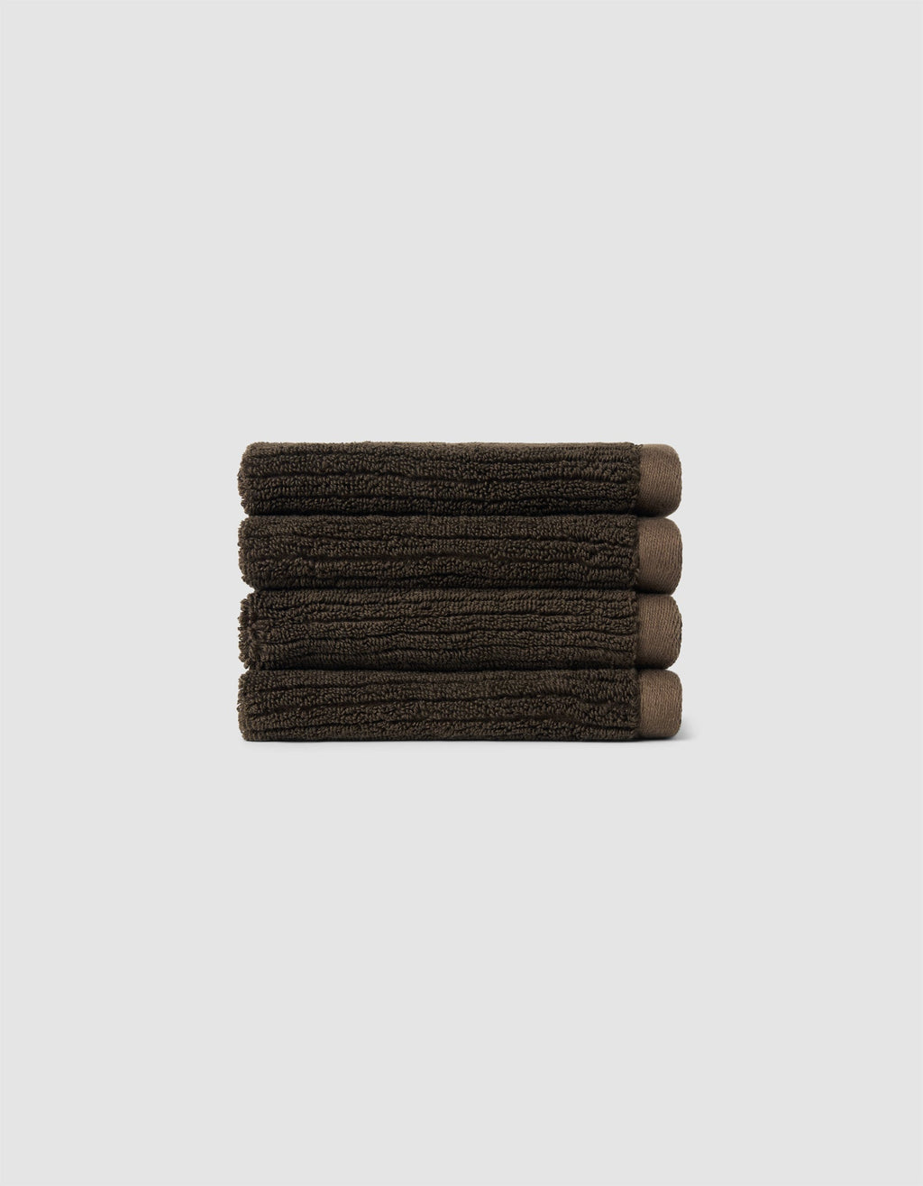 The Cozy Earth Complete Ribbed Terry Bath Bundle, featuring four dark brown towels, is arranged horizontally against a plain light gray background.|Color:Espresso