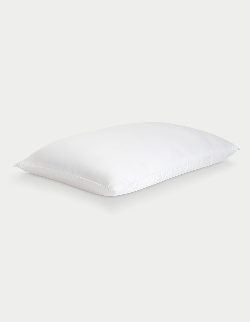 The Cozy Earth Silk Pillow, soft and rectangular with neatly finished edges, is shown against a light gray background. Its smooth white fabric highlights the luxurious feel of this premium pillow.