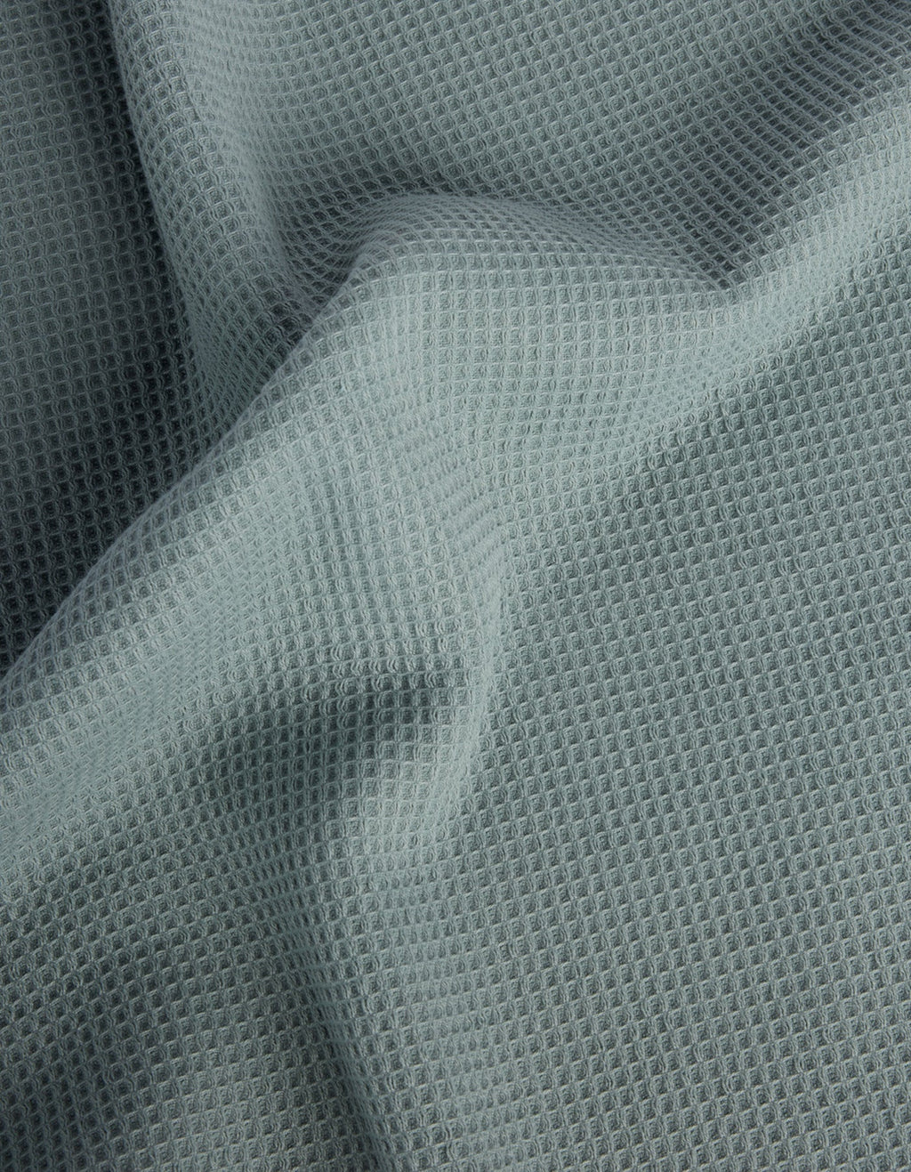 The Cozy Earth Waffle Bath Towel Set features light gray, waffle-textured fabric with a soft, grid-like pattern and gentle folds across the surface. |Color:Brook