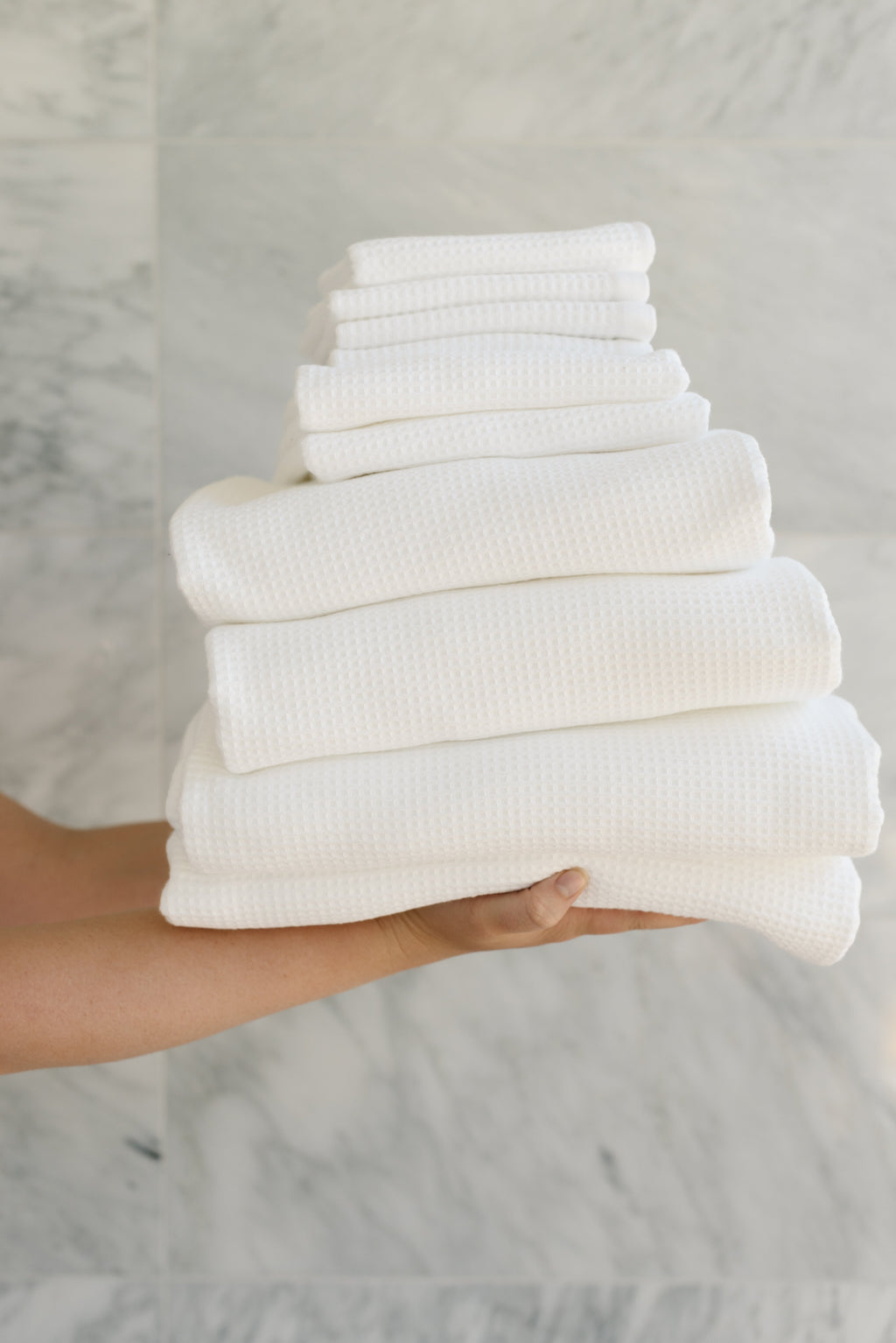 Complete Waffle Bath Bundle in the color White. Photo of White Complete Waffle Bath Bundle taken while being held by a persons outreached hands |Color:White