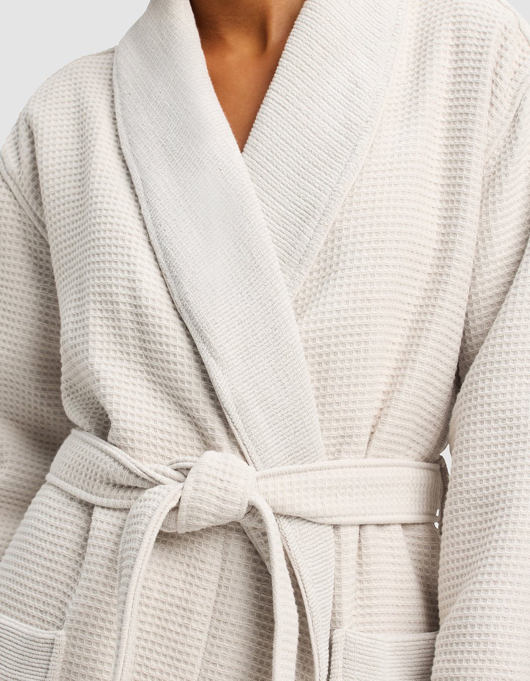 A person wears the Cozy Earth Waffle Bath Robe in light beige, featuring waffle texture, wide lapels, two front pockets, and a matching waist tie.|Color:Light Grey