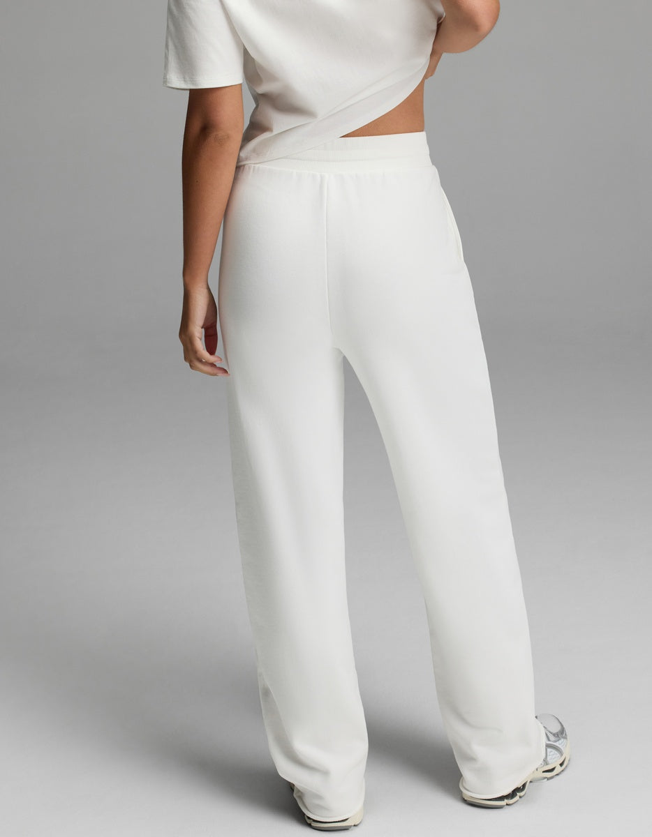A person, visible from the waist down, is wearing Cozy Earth’s Women’s Chelsea Pant in white. The background is plain gray.|Color:Bone