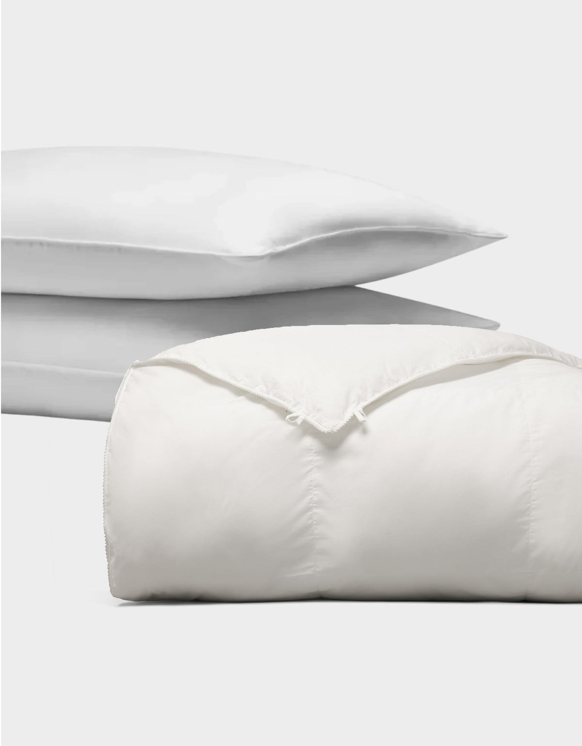 The Cozy Earth Down Alternative Insert Bundle, featuring two stacked white pillows and a folded comforter, is displayed against a plain white background.|Filling:Standard